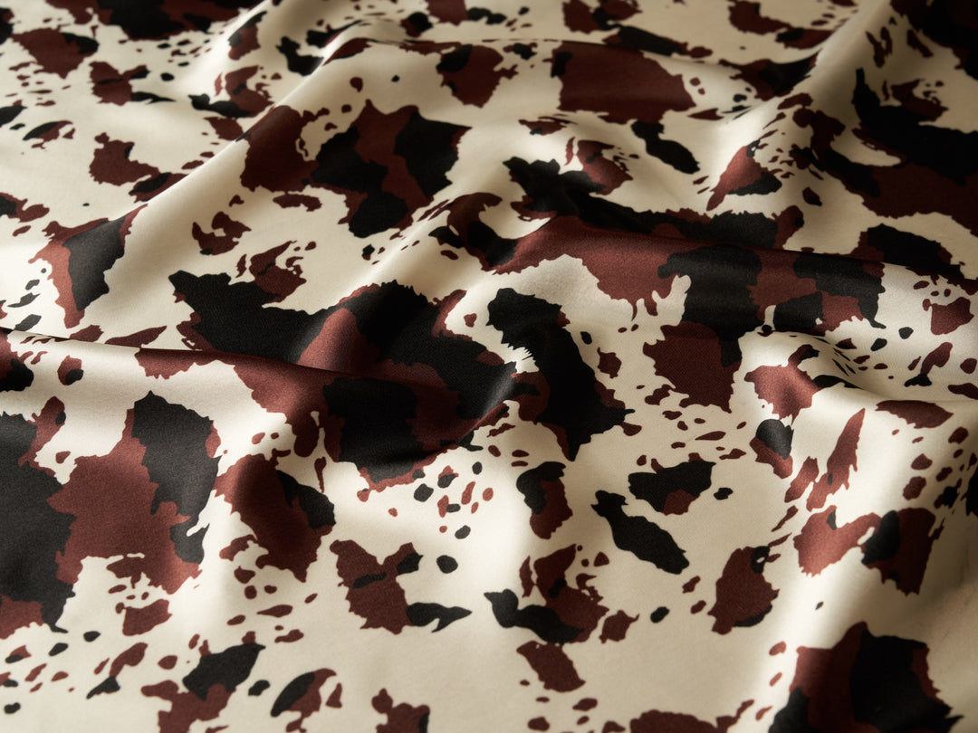 Charmeuse satin fabric by the yard - Black burgundy off white cow animal print