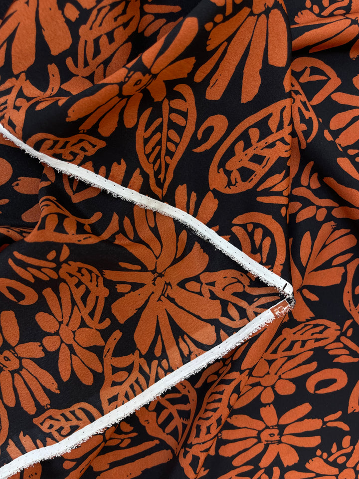 Crepe de Chine fabric by the yard - Orange paisley floral on black