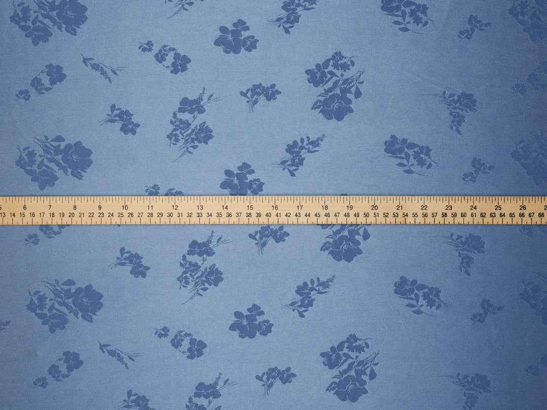 Blue floral patterned fabric with a ruler at the bottom for scale.