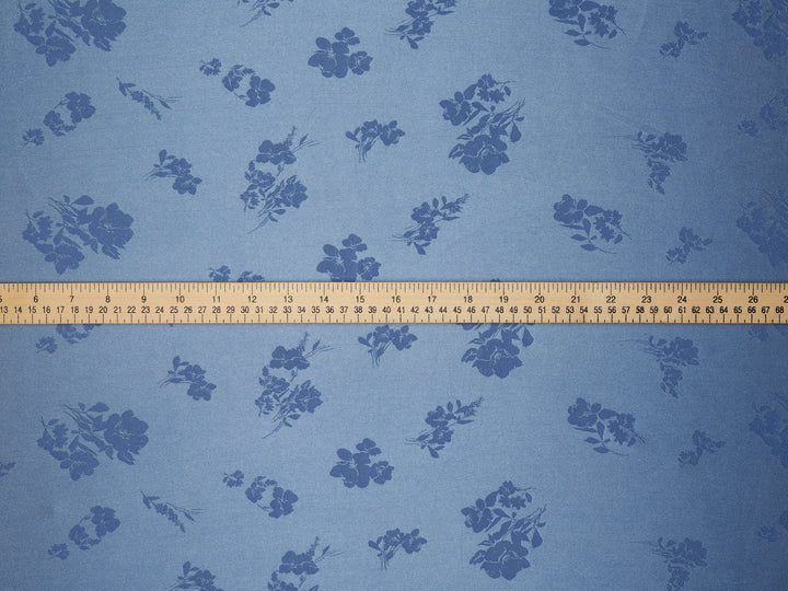 Blue floral patterned fabric with a ruler at the bottom for scale.