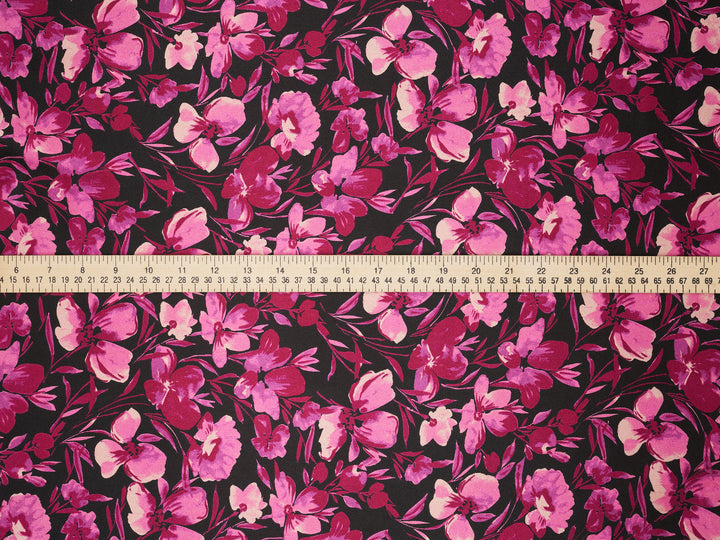 Floral fabric pattern with a ruler at the bottom for scale on a dark background