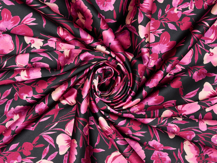 Roll of fabric with pink floral pattern on black background