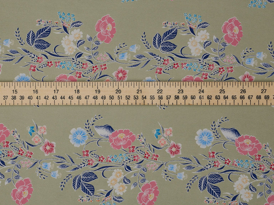 Floral patterned fabric with a ruler at the bottom for scale on a green background