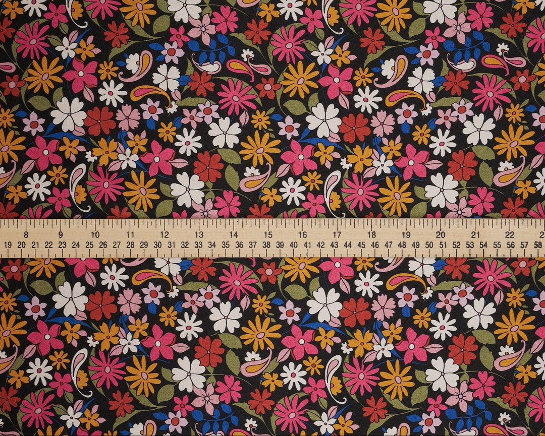 Floral fabric pattern with a ruler at the bottom for scale. Black pink paisley and floral print 