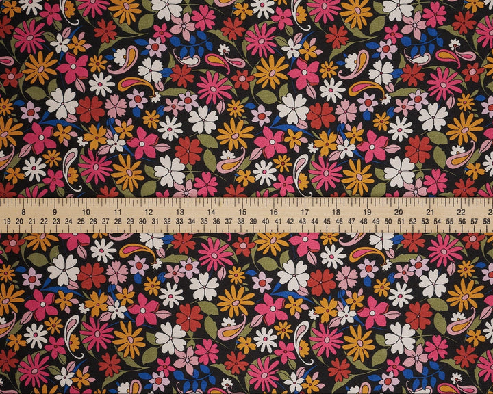 Floral fabric pattern with a ruler at the bottom for scale. Black pink paisley and floral print 