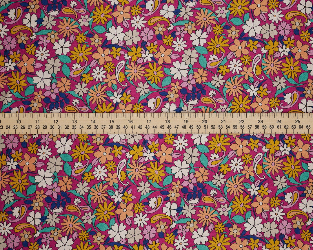 Colorful floral fabric with a ruler at the bottom for scale. Pink paisley 