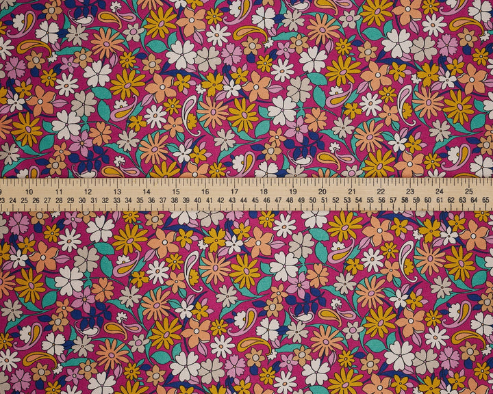 Colorful floral fabric with a ruler at the bottom for scale. Pink paisley 