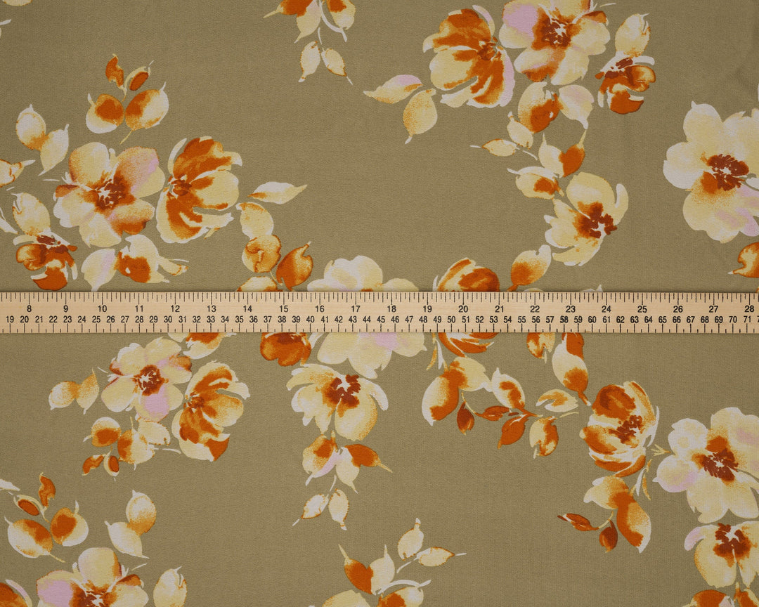 Floral patterned fabric with a ruler for scale on a beige background