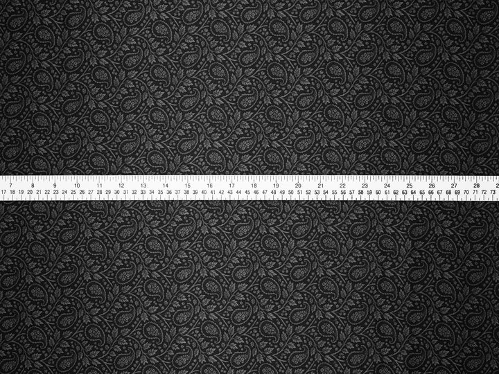 Black textured fabric with a measuring tape at the bottom