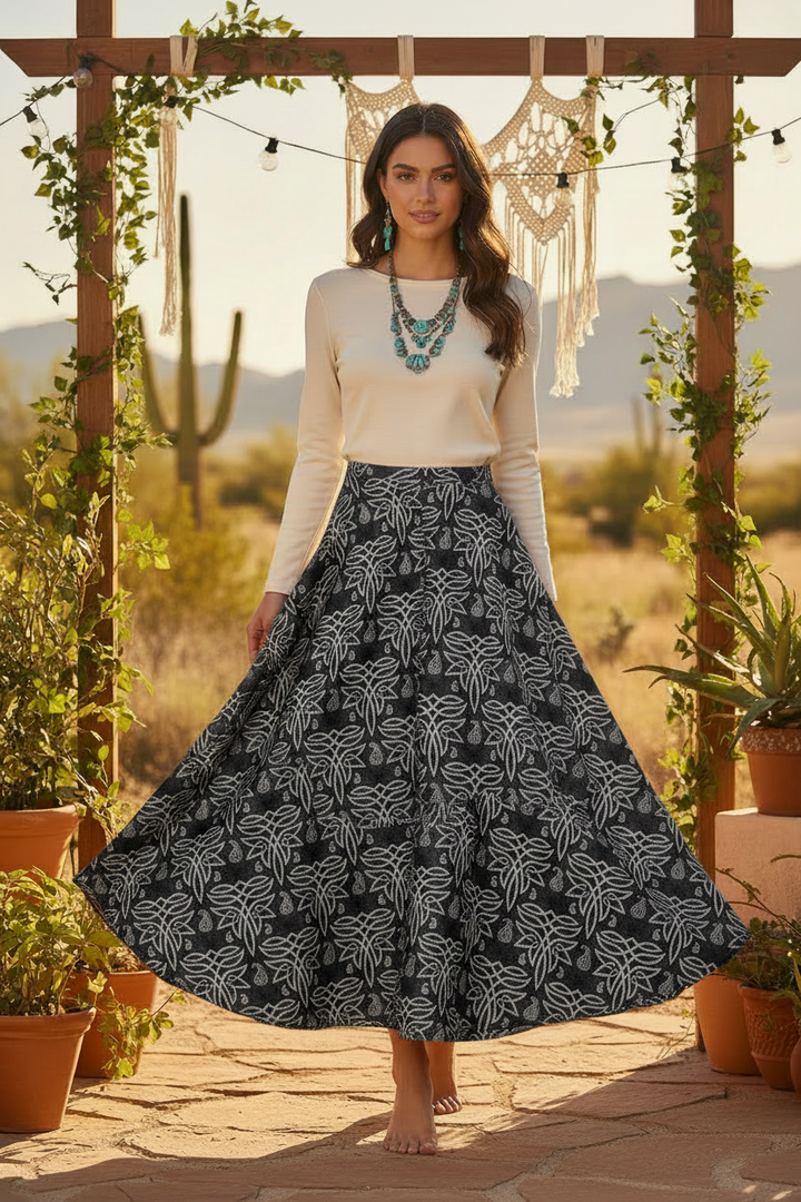 Brunette model in boho desert setting wearing flowing maxi skirt made from dark Celtic paisley satin charmeuse fabric with ivory top and turquoise jewelry