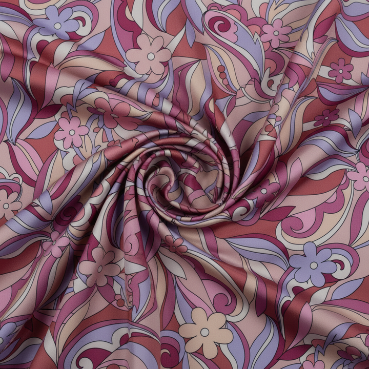 Close-up of pink burgundy lavender paisley satin charmeuse fabric with elegant swirls and draping showcasing the sheen