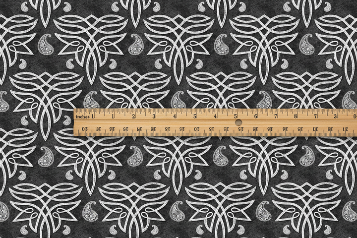 Dark Celtic paisley fabric with wooden ruler showing 3 inch motif scale