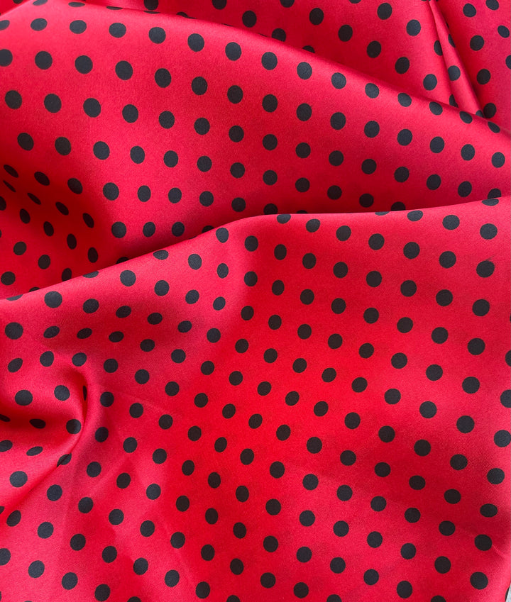 Faux silk charmeus satin fabric by the yard - black polka dots on red